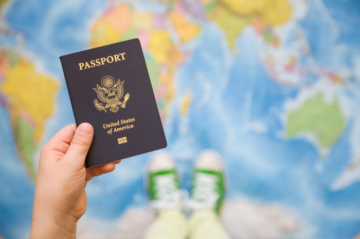 Child's hand holding US passport. Map background. Ready for traveling. Open world.